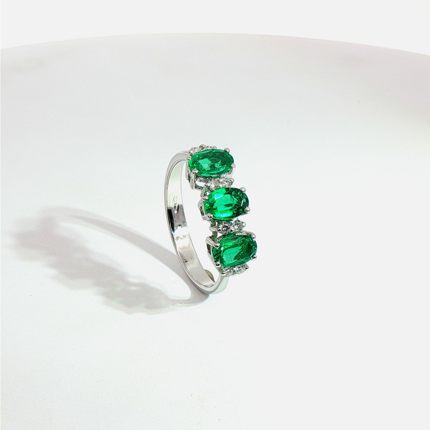 Anello in oro bianco con smeraldi Lab-Grown taglio ovale e diamanti Lab-Grown taglio brillante.