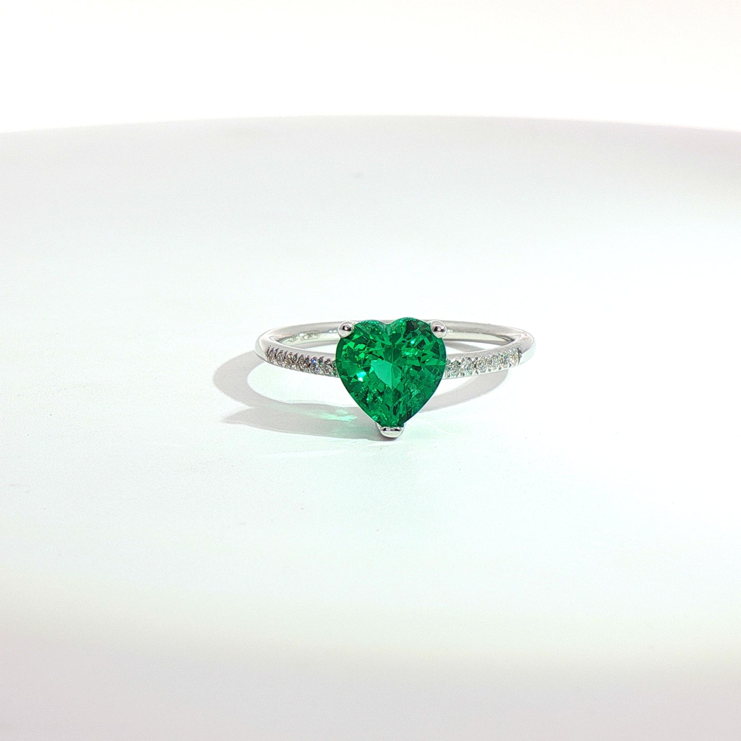 Solitario in oro bianco con smeraldo Lab-Grown taglio cuore e diamanti lab-grown taglio brillante.
