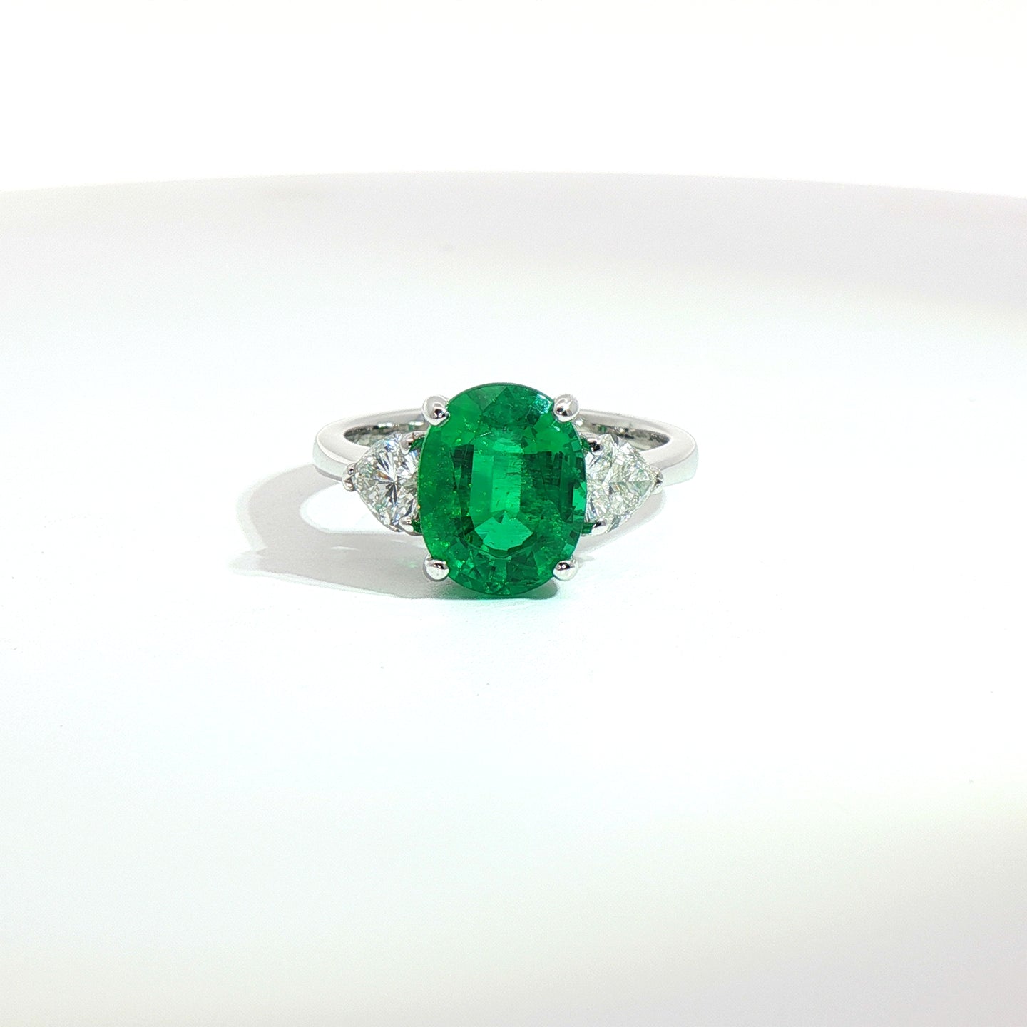 Anello in oro bianco con smeraldo Lab-Grown taglio ovale e diamanti Lab-Grown taglio cuore.