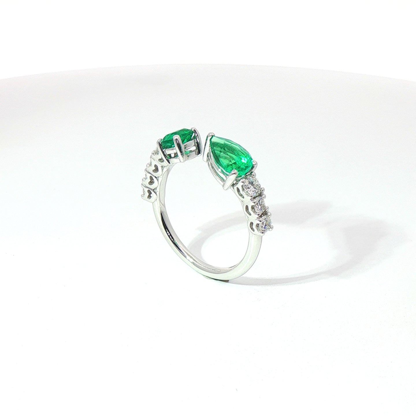 Anello in oro bianco con smeraldi Lab-Grown taglio goccia e ovale, con diamanti Lab-Grown taglio brillante.