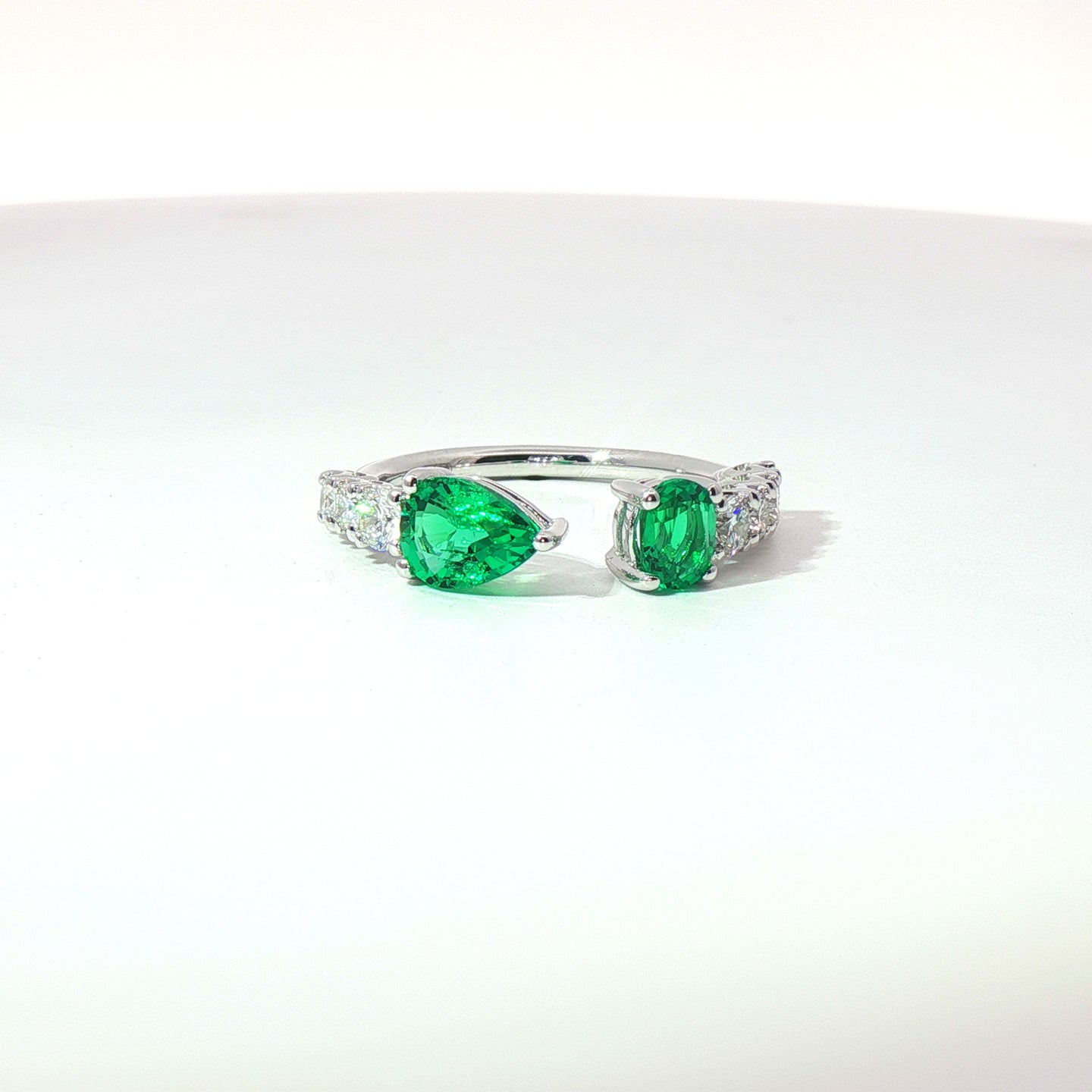 Anello in oro bianco con smeraldi Lab-Grown taglio goccia e ovale, con diamanti Lab-Grown taglio brillante.