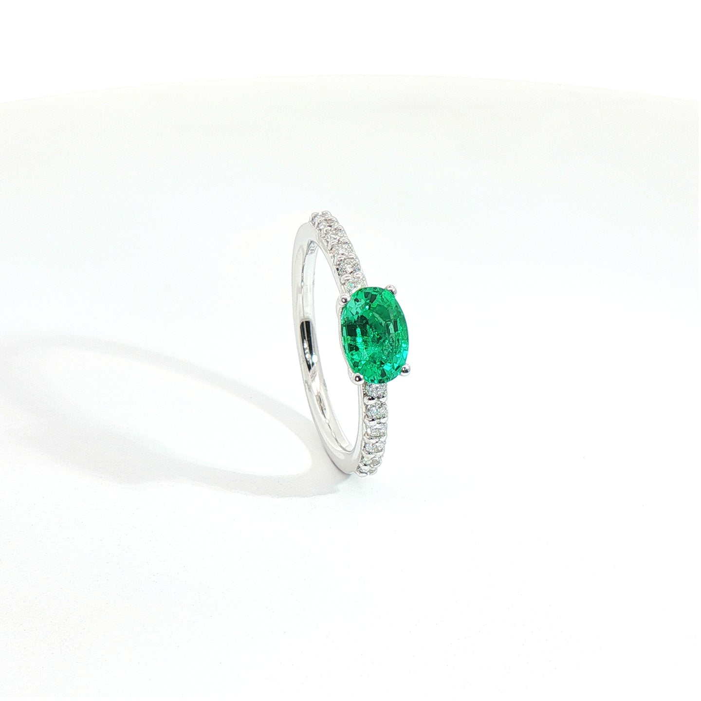 Anello in oro bianco con smeraldo Lab-Grown taglio ovale e diamanti Lab-Grown taglio brillante.