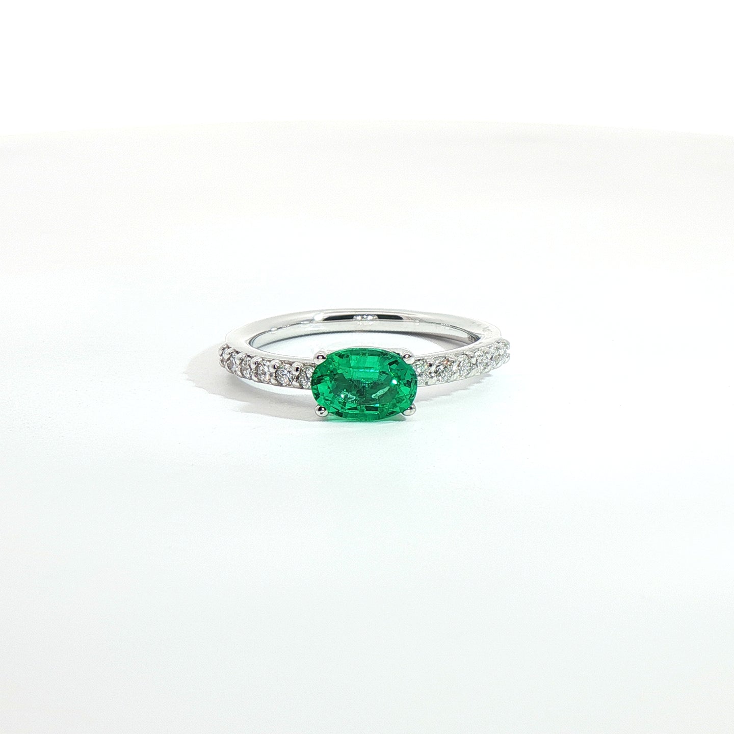 Anello in oro bianco con smeraldo Lab-Grown taglio ovale e diamanti Lab-Grown taglio brillante.