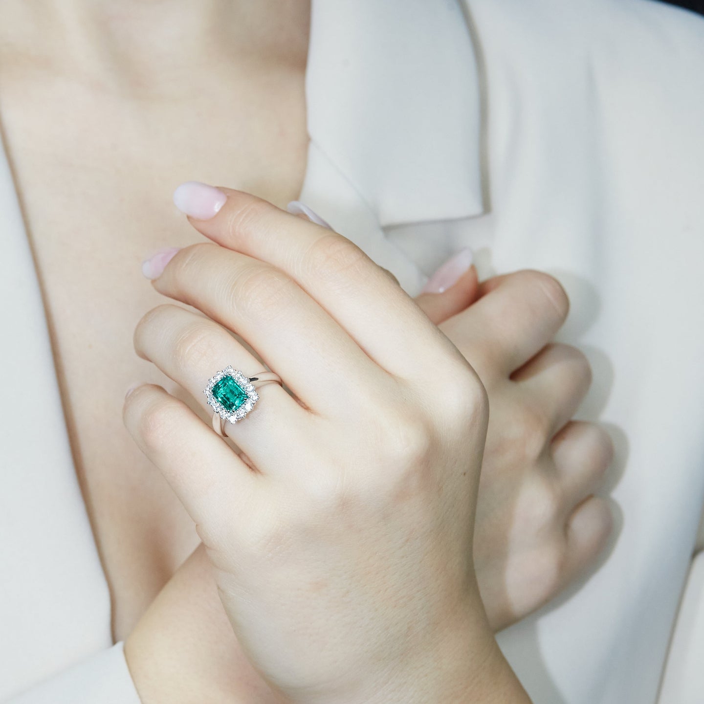 Anello in oro bianco con smeraldo lab-grown e diamanti lab-grown taglio brillante.