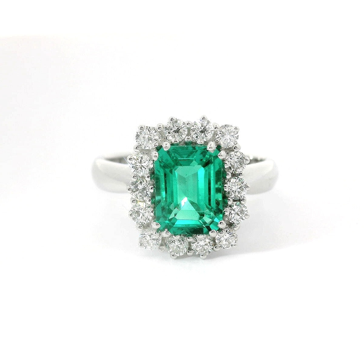 Anello in oro bianco con smeraldo lab-grown e diamanti lab-grown taglio brillante.