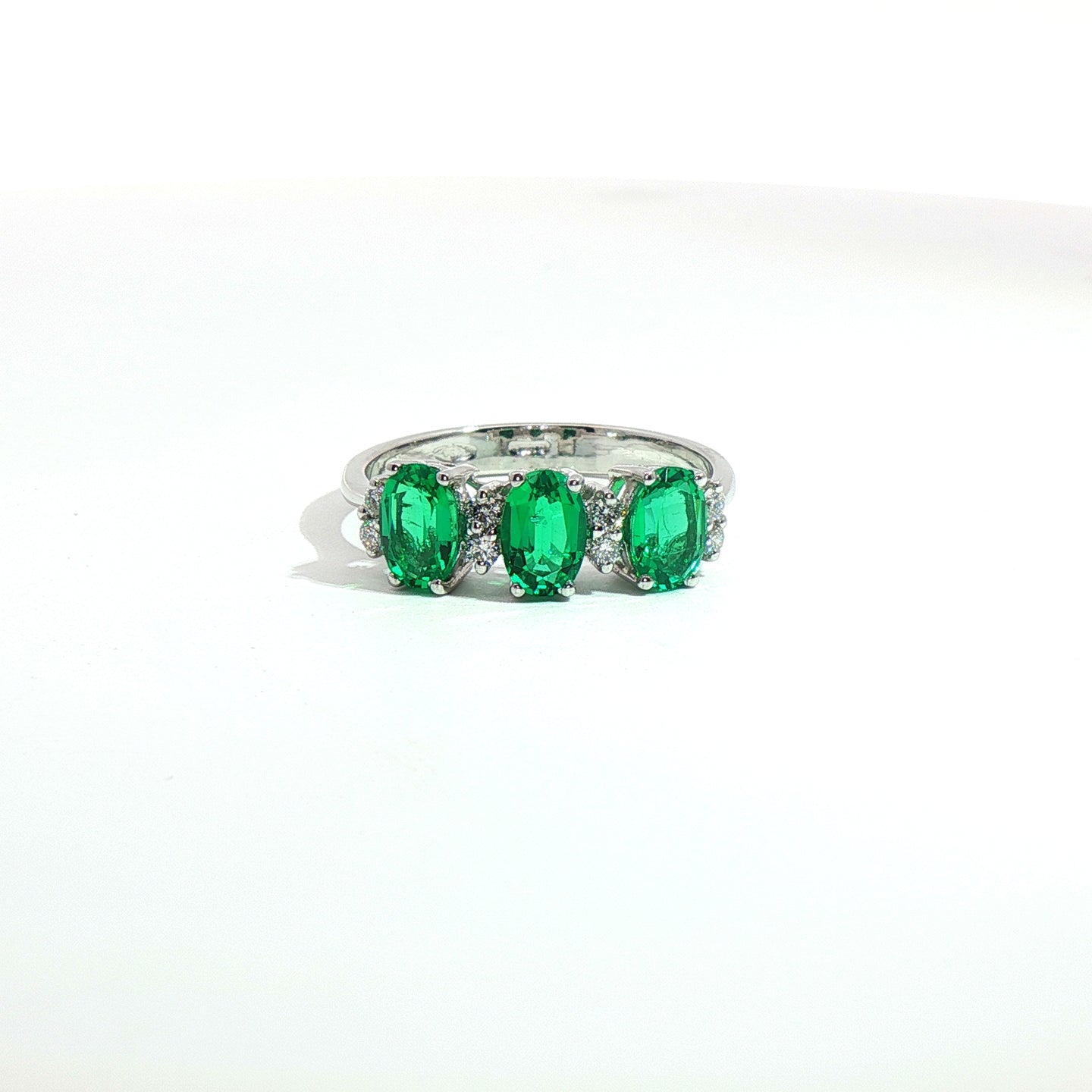 Anello in oro bianco con smeraldi Lab-Grown taglio ovale e diamanti Lab-Grown taglio brillante.