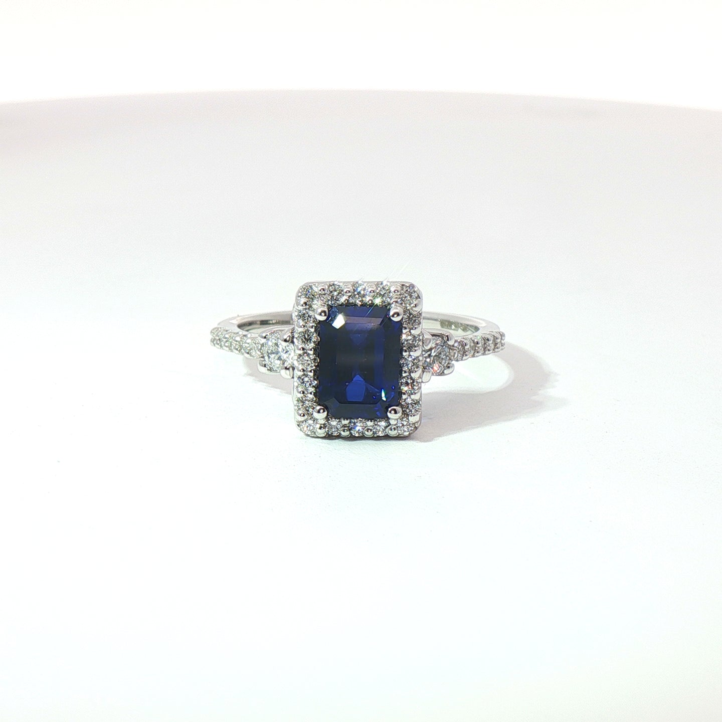 Anello in oro bianco con zaffiro Lab-Grown taglio smeraldo e diamanti Lab-Grown taglio brillante.