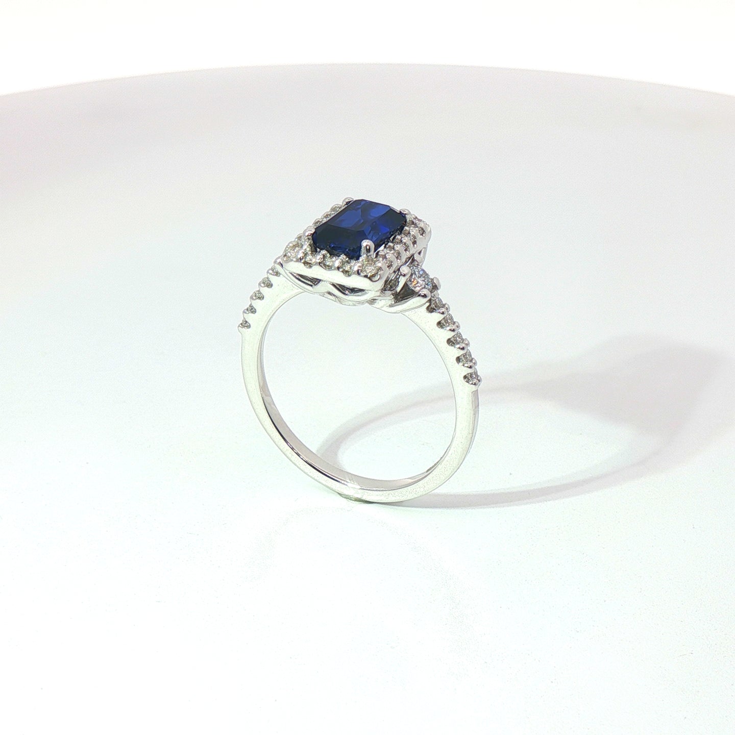 Anello in oro bianco con zaffiro Lab-Grown taglio smeraldo e diamanti Lab-Grown taglio brillante.