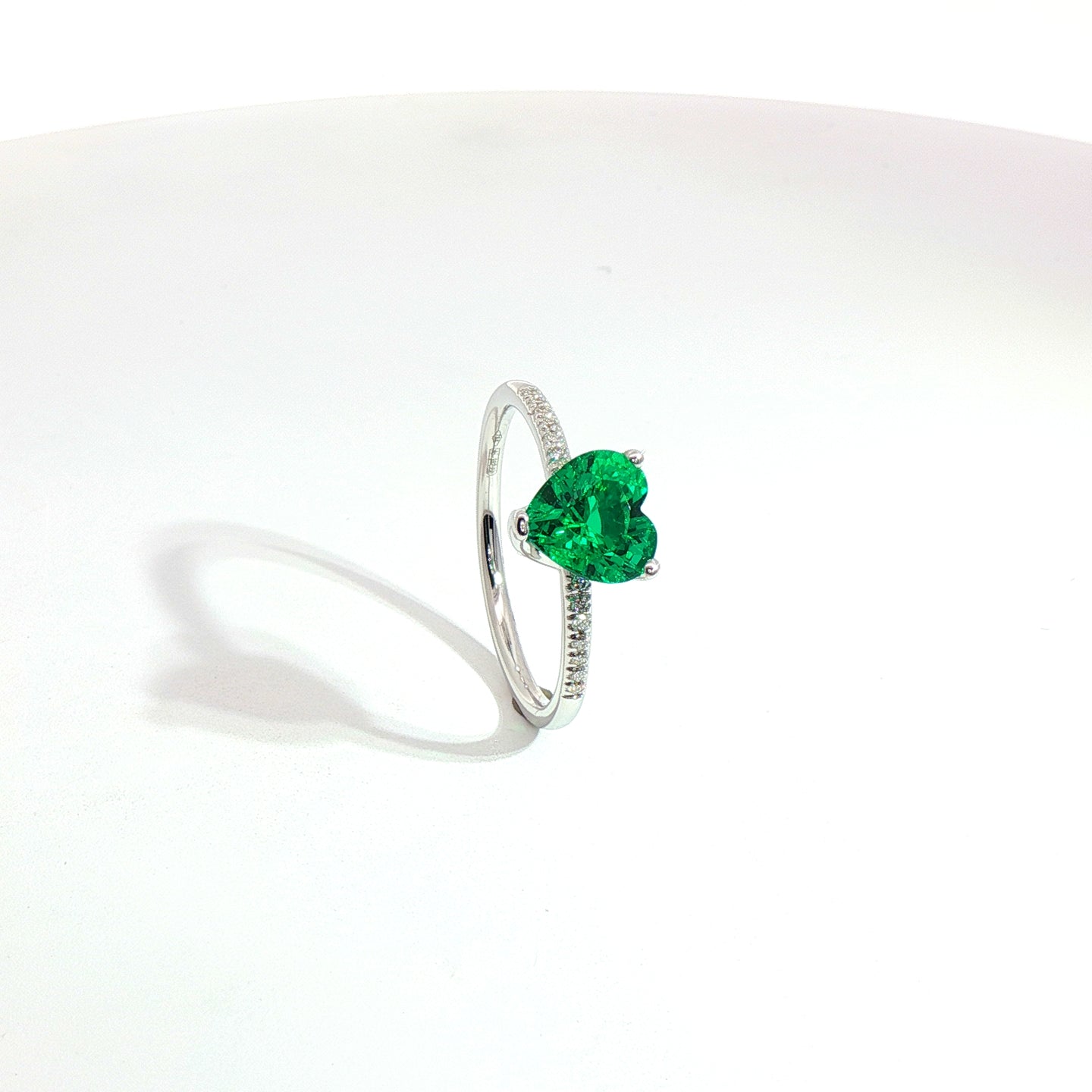 Solitario in oro bianco con smeraldo Lab-Grown taglio cuore e diamanti lab-grown taglio brillante.