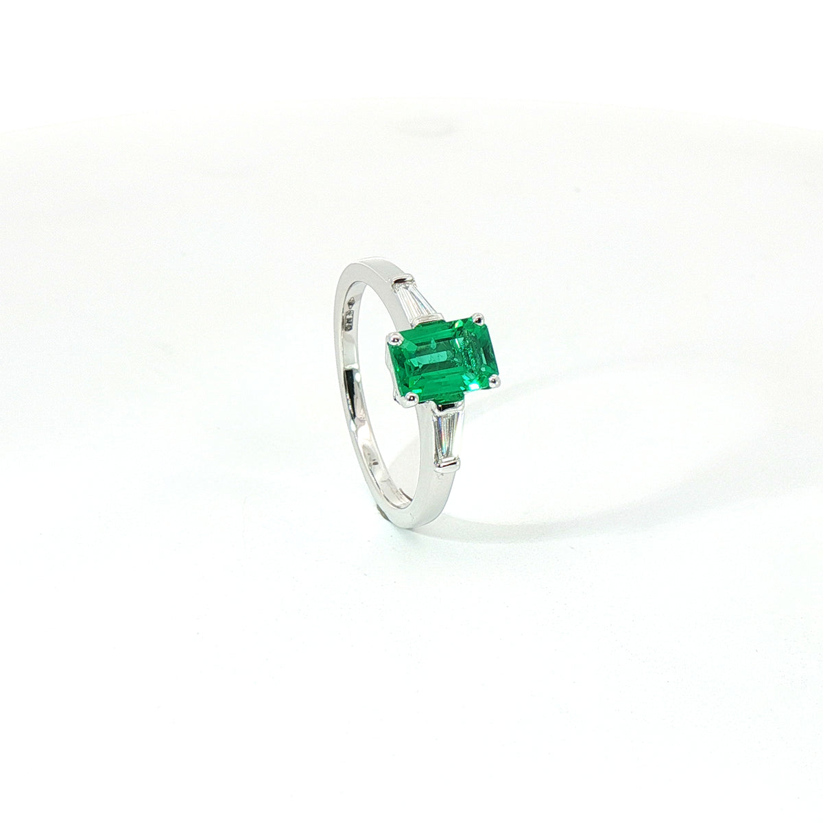 Anello in oro bianco con smeraldo Lab-Grown taglio smeraldo e diamanti Lab-Grown taglio taper.