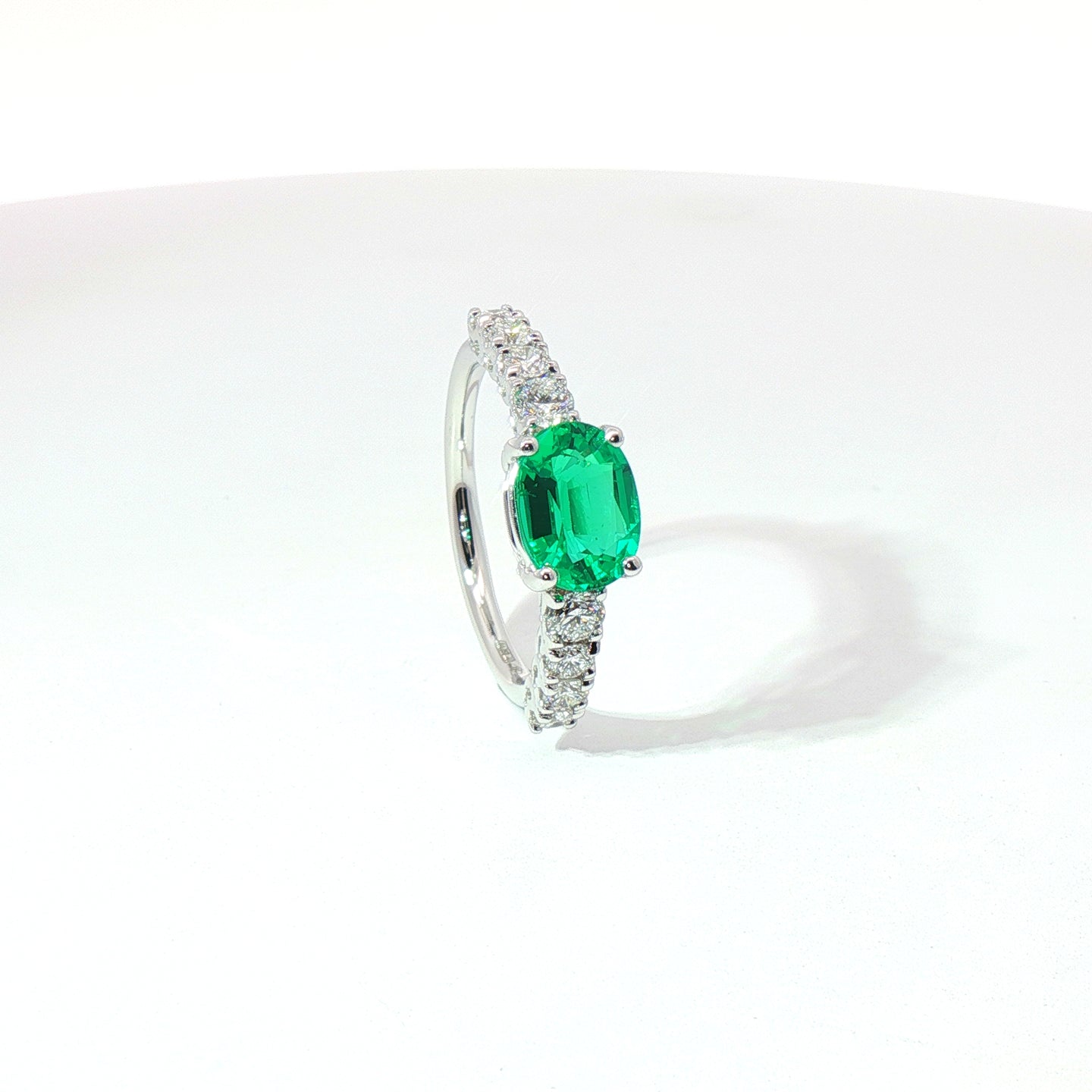 Anello in oro bianco con smeraldo Lab-Grown taglio ovale e diamanti Lab-Grown taglio brillante.