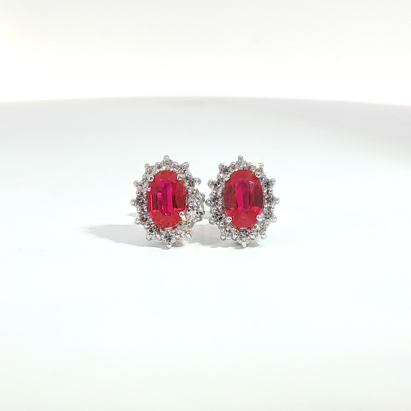 Orecchini punto luce in oro bianco con rubini Lab-Grown taglio ovale e diamanti Lab-Grown taglio brillante.