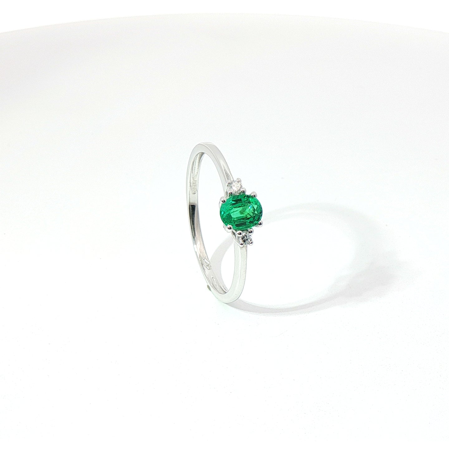 Anello Trilogy in oro bianco con smeraldo Lab-Grown taglio ovale e diamanti Lab-Grown taglio brillante.