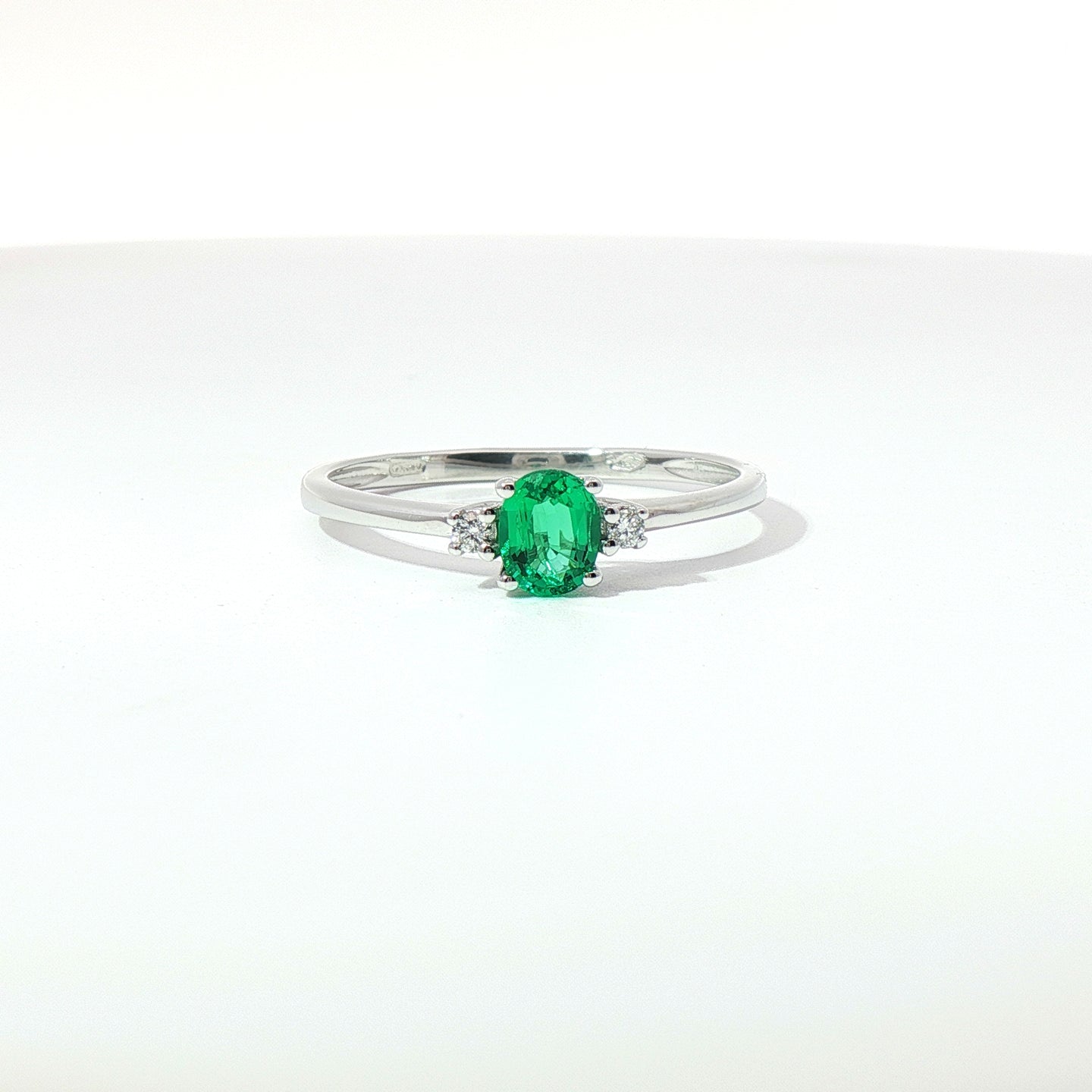 Anello Trilogy in oro bianco con smeraldo Lab-Grown taglio ovale e diamanti Lab-Grown taglio brillante.