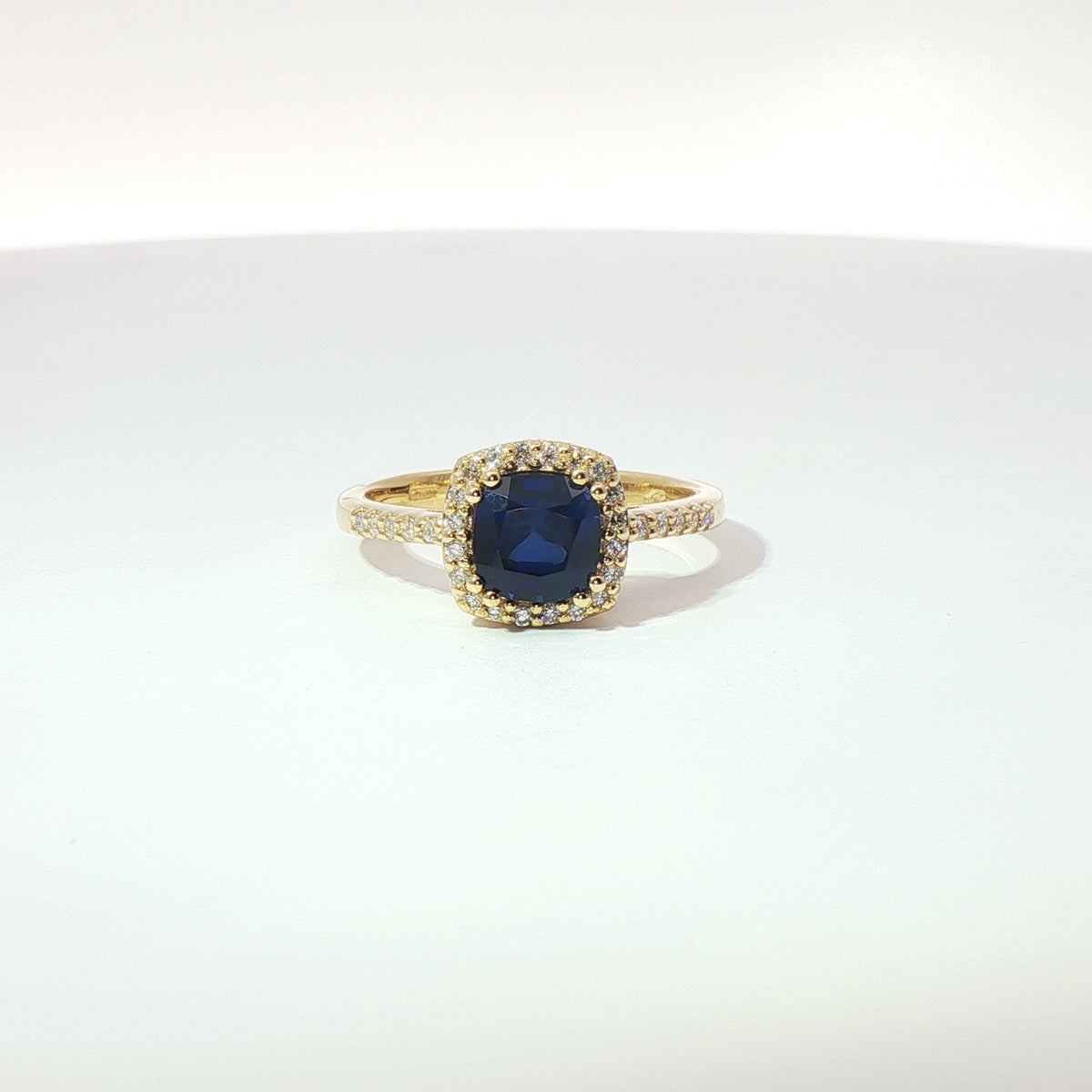 Anello in oro giallo con zaffiro taglio cuscino e diamanti Lab-Grown taglio brillante.