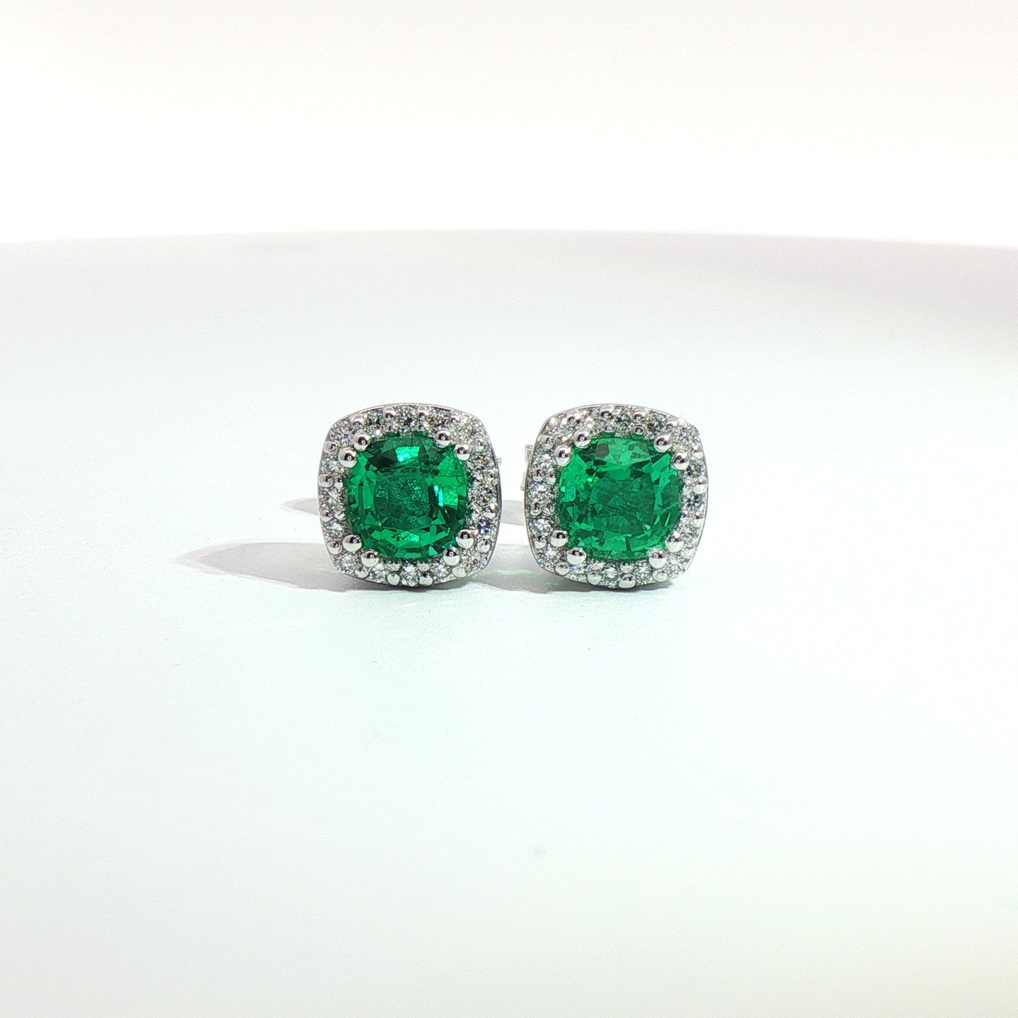 Orecchini punto luce in oro bianco con smeraldi Lab-Grown taglio cuscino e diamanti Lab-Grown taglio brillante.
