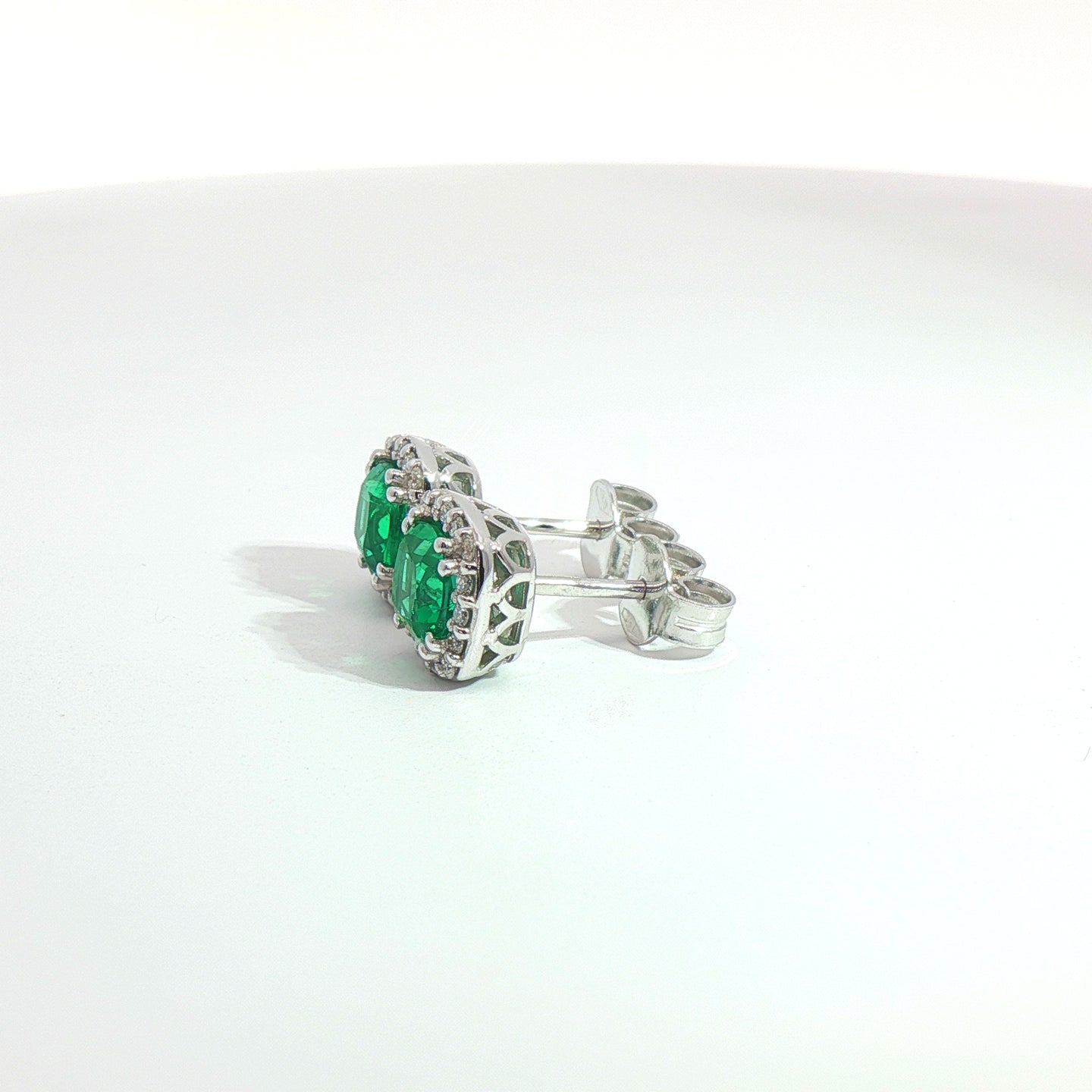 Orecchini punto luce in oro bianco con smeraldi Lab-Grown taglio cuscino e diamanti Lab-Grown taglio brillante.